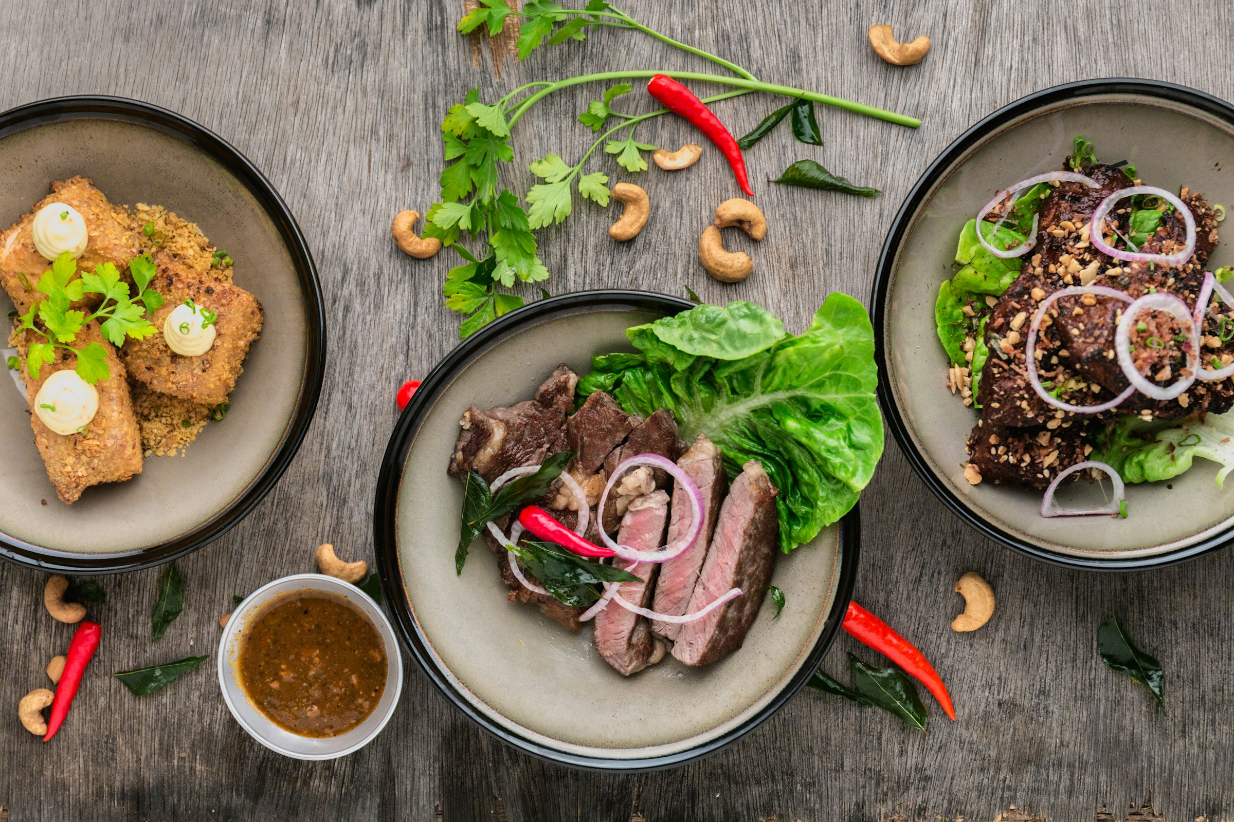 Gourmet plated feast with steak, fries, and fresh greens under warm restaurant lighting